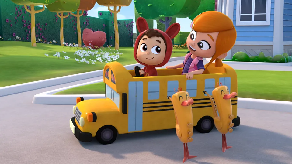 Lea y Pop montados en un autobús escolar de juguete con sus juguetes musicales